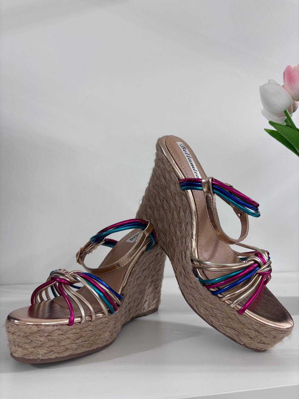 Beige woven espadrille wedge sandals with colorful striped fabric straps and ankle buckle closure.