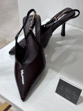 Brown patent leather slingback heels with pointed toe and thin buckle strap.