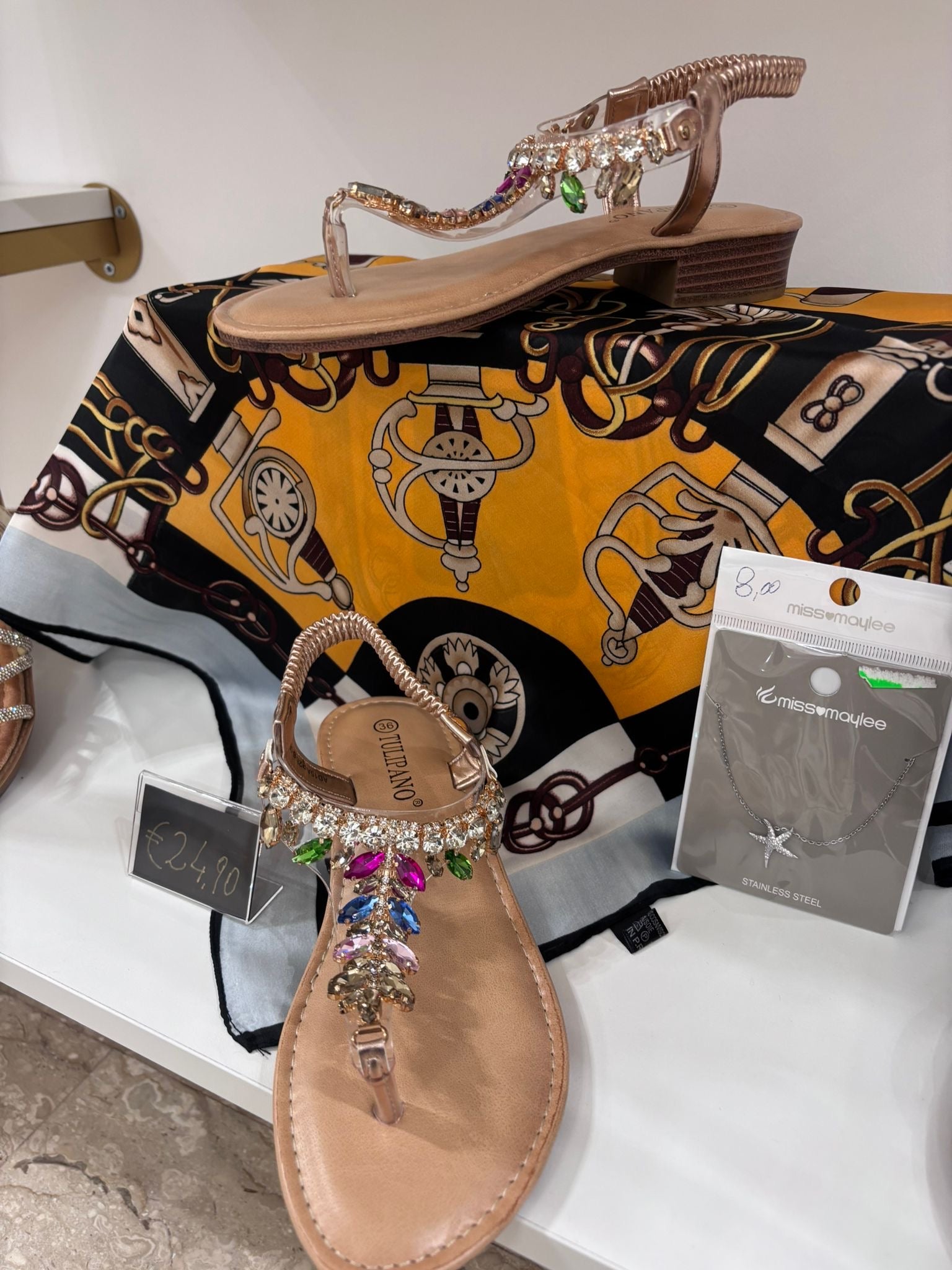 Gold thong sandals with jeweled straps and cushioned footbed on patterned silk scarf.