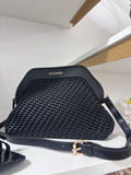 Black woven leather cocco bag with structured frame and adjustable strap.