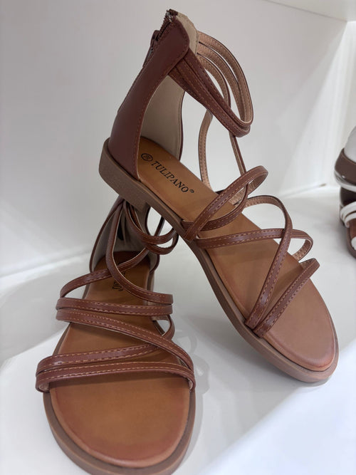 Brown leather flat sandals with braided straps and ankle ties.