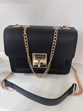 Black leather shoulder bag with flap closure and gold chain strap.