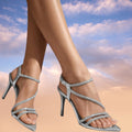 Silver strappy high-heel sandals with rhinestone embellishments and open toe design.