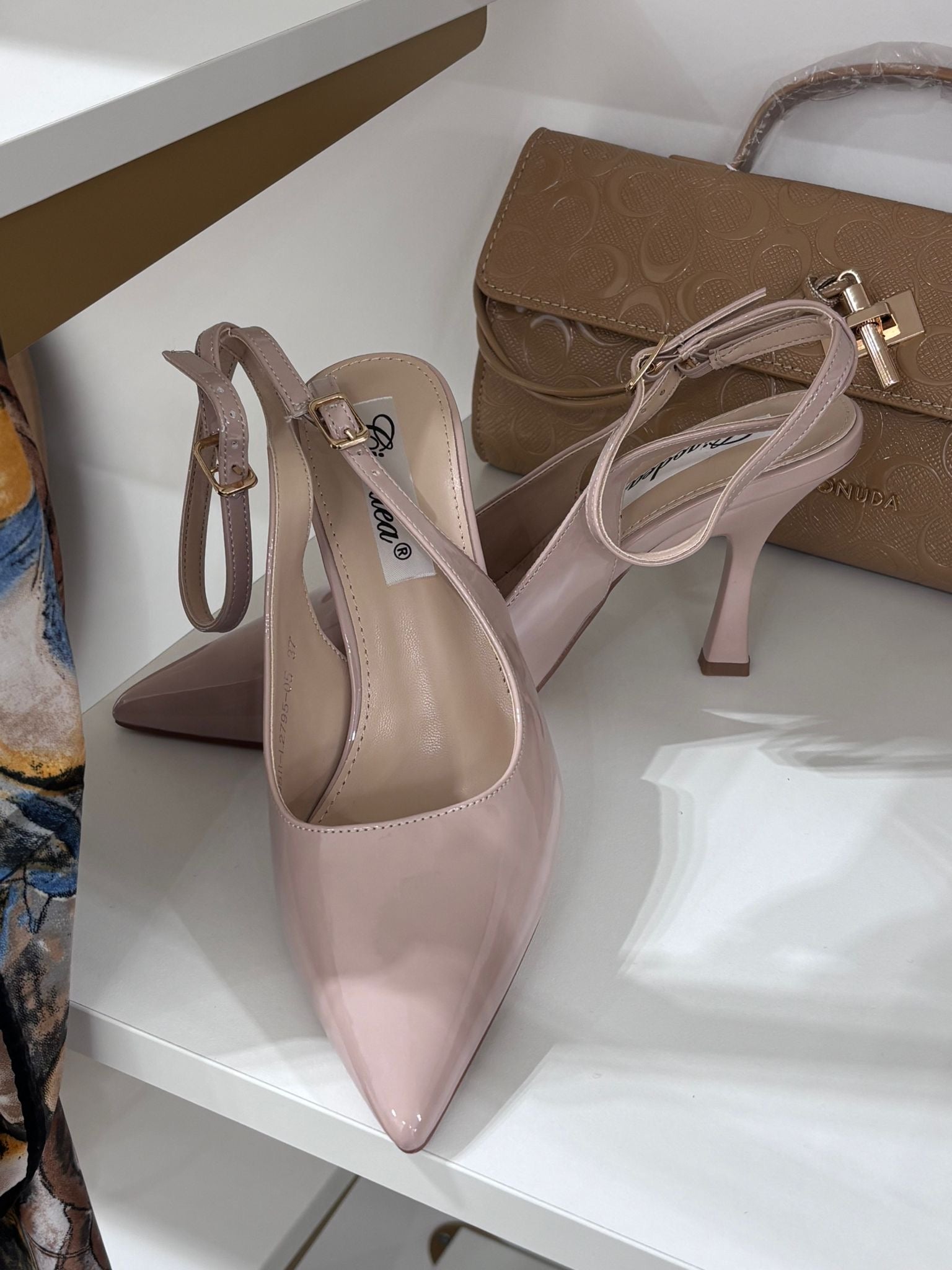 Nude glossy pointed slingback heels with double ankle straps and mid-height slim heels.