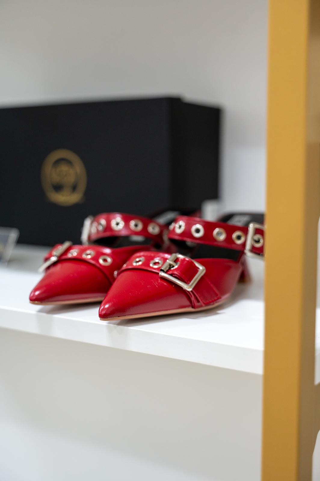Red pointed mule sandals with silver studs and side buckles on low block heels.