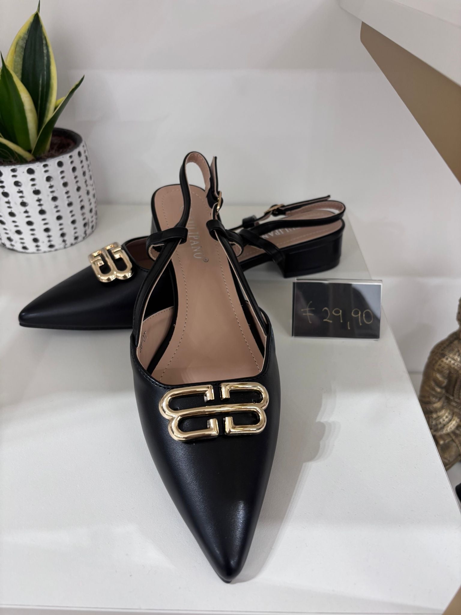 Black leather pointed-toe slingback flats with gold double-B embellishment and low block heel.