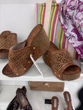 Camel brown wedge sandals with perforated leather upper and open toe design.