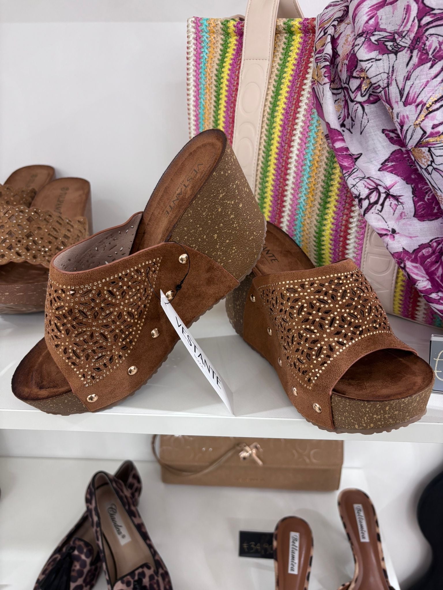 Camel brown wedge sandals with perforated leather upper and open toe design.