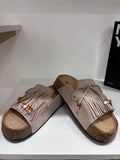Beige suede flat summer sandals with fringe detail and wooden bead accents on cork sole.