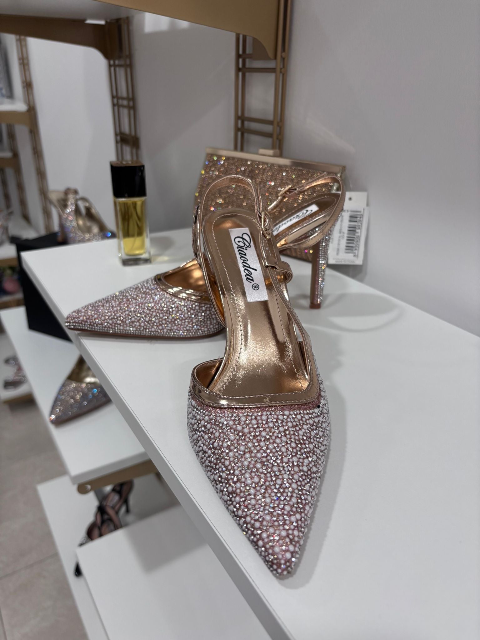 Gold slingback high heel with pointed toe covered in sparkling rhinestones and slim ankle strap.