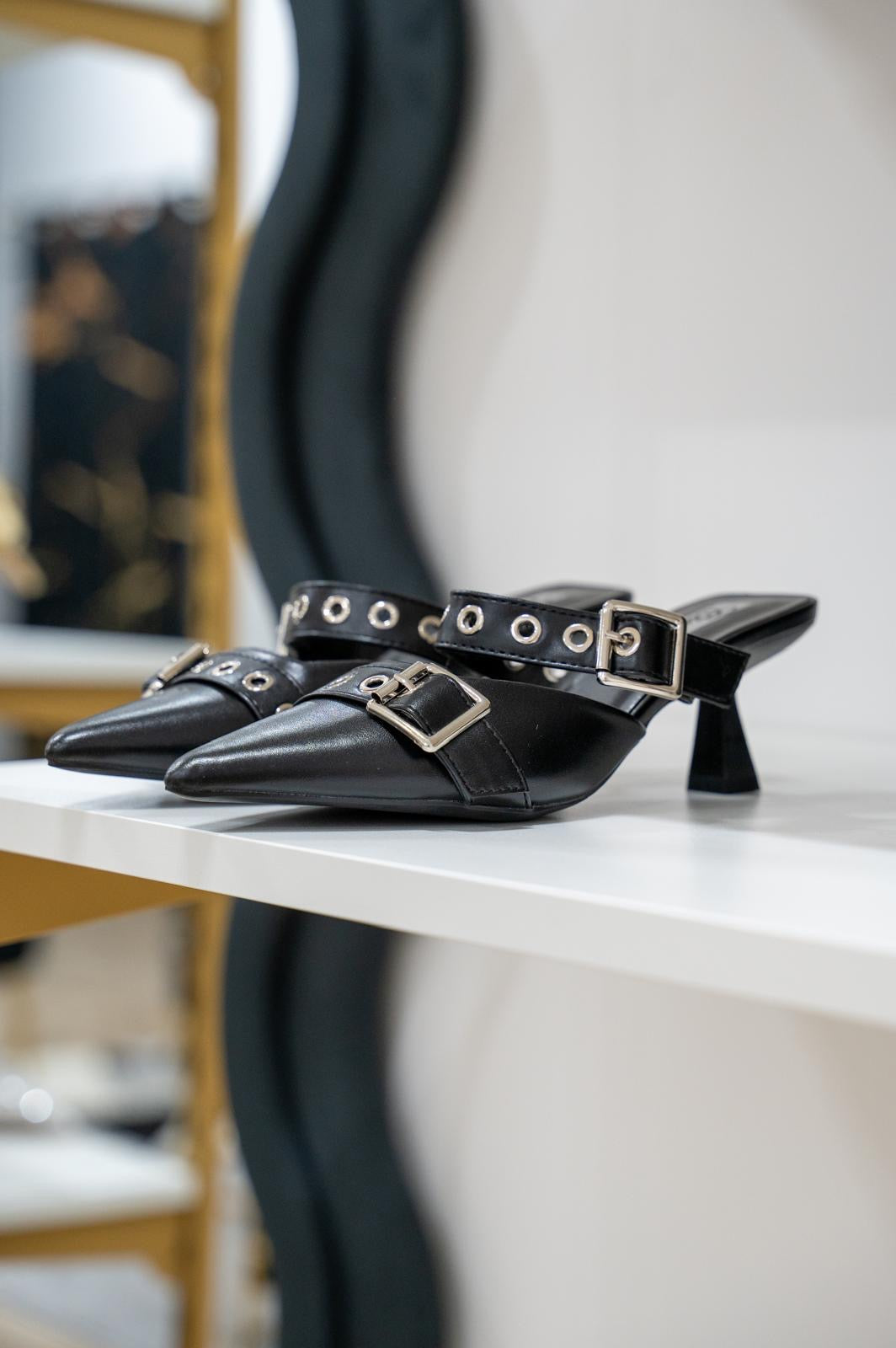 Black leather pointed-toe mule with studded strap and small block heel.